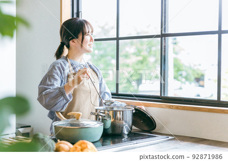 Asian woman cooking in the kitchen (curry stew) Asian woman cooking in the kitchen (curry stew) 92871986