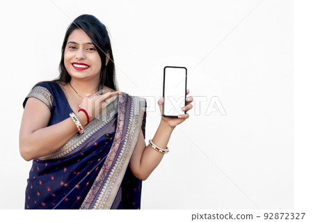 Advertisement concept - Pretty Indian young woman showing smartphone or mobile blank screen Advertisement concept - Pretty Indian young woman showing smartphone or mobile blank screen 92872327