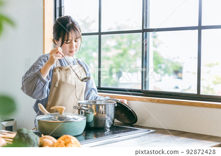 Asian woman cooking in the kitchen (failure/fatigue) 92872428