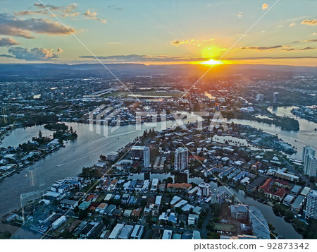 GOLD COAST, AUSTRALIA - APRIL 25, 2021 Aerial panorama view of High-rise building sky scrapers with inland canal and Surfer Paradise city skyline landscape with Sunset light in the evening. 92873342
