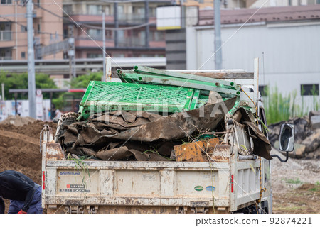 A truck collecting weed control sheets from a construction site A truck collecting weed control sheets from a construction site 92874221