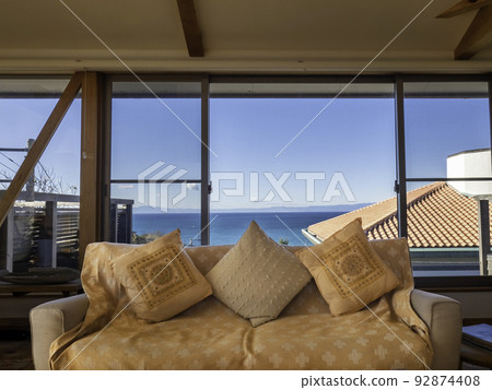 A living space with a window overlooking the sea 92874408