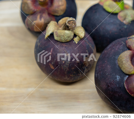 Closeup view of ripe mangosteen on wooden table 92874606
