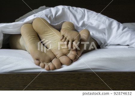 Man and woman legs under duvet 92874632