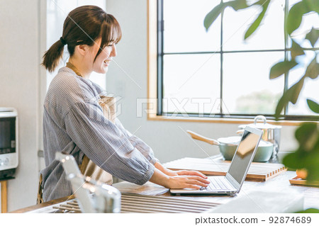 亞洲女性在電腦上查找食譜 亞洲女性在電腦上查找食譜 92874689