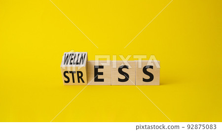 Wellness and Stress symbol. Turned Wooden cubes with word Wellness and Stress. Beautiful yellow background. Business and Wellness and Stress concept. Copy space. Wellness and Stress symbol. Turned Wooden cubes with word Wellness and Stress. Beautiful yellow background. Business and Wellness and Stress concept. Copy space. 92875083