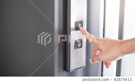 Male forefinger pressing on button up elevator 92875613