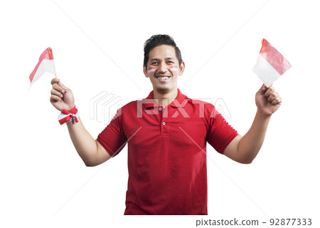 Indonesian men celebrate Indonesian independence day on 17 August by holding the Indonesian flag 92877333