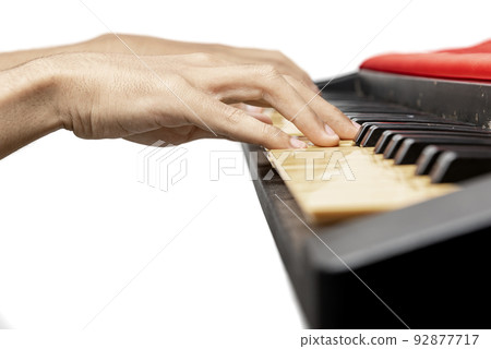 Closeup view of human hand playing electronic piano keyboard 92877717