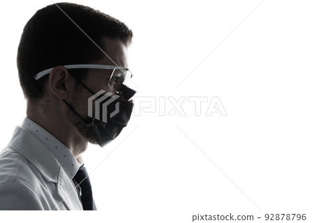 Closeup silhouette portrait of a male dentist wearing dental binocular loupes isolated on white 92878796