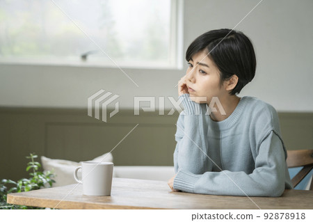 A young woman who thinks with a cane on her cheek 92878918