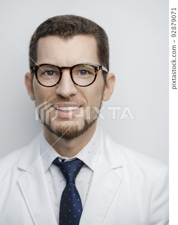 Portrait of happy young bearded male doctor smiling with eyeglasses isolated on white background 92879071