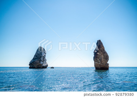 Two rocks stick out of the water in the middle of the turquoise sea. Scenic ocean views. High quality photo. Like in Iceland 92879380