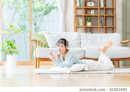 Young woman looking at her smartphone in the living room 92881690