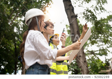 engineering and construction managers discussing project blue print on the table at construction site 92882289