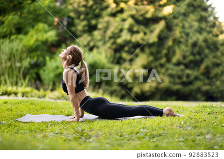 Side view of athletic woman standing in yoga pose Side view of athletic woman standing in yoga pose 92883523