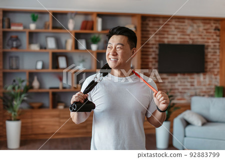 Active sporty lifestyle. Happy asian mature man holding resistance bands hang around his neck 92883799