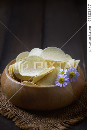 Potato chips bowl on wood background, fat food or junk food Potato chips bowl on wood background, fat food or junk food 92883807