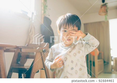 一個孩子睡眼惺忪地揉著眼睛看著相機 92884461