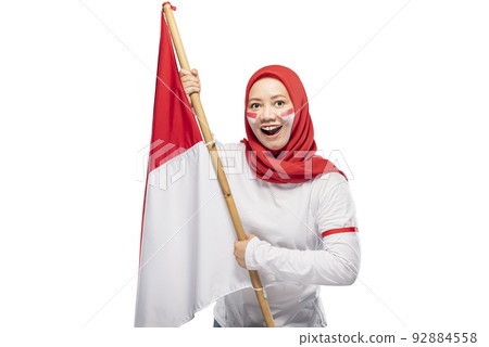Indonesian women celebrate Indonesian independence day on 17 August by holding the Indonesian flag 92884558