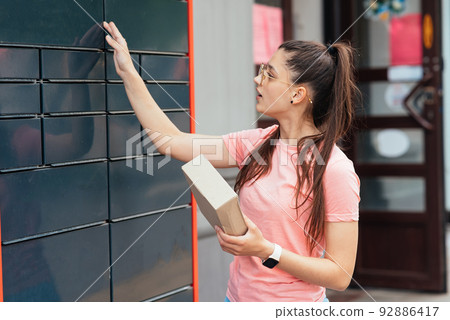 Woman preparing parcel for shipment to client near post office 92886417