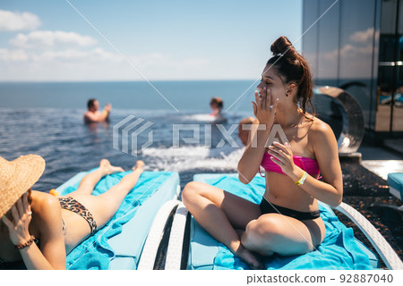 Young beautiful woman in swimsuit sunbathes on a sun lounger 92887040
