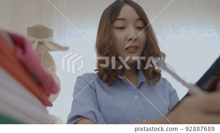 Business concept of 4k Resolution. Asian woman checking goods at the office. taking notes. 92887689