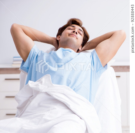 Young male patient lying on couch in hospital Young male patient lying on couch in hospital 92888443