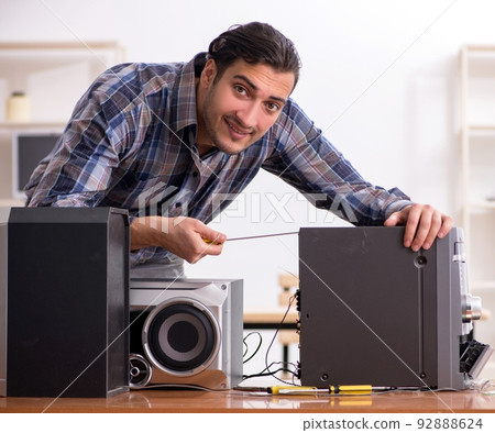 Young engineer repairing musical hi-fi system Young engineer repairing musical hi-fi system 92888624