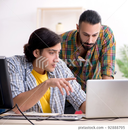 Two it specialists working in the office 92888705