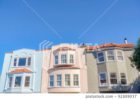 Three adjacent houses with clay roof tiles against the blue sky at San Francisco, California 92889037