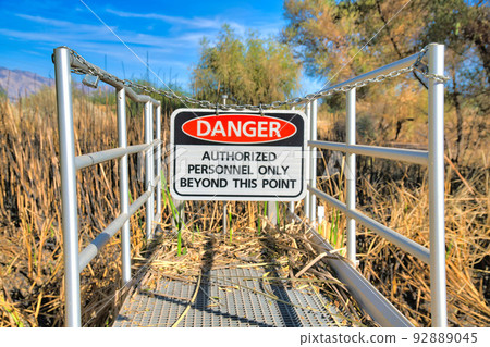 Hanging danger sign on a chainlink at Sweetwater Wetlands in Tucson, Arizona 92889045