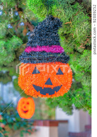 Tinsel plaque halloween pumpkin with hat ornament hanging on a tree at San Francisco, California Tinsel plaque halloween pumpkin with hat ornament hanging on a tree at San Francisco, California 92889252