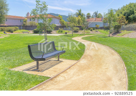 Bench beside the dirt trail in a park at San Diego, California 92889525