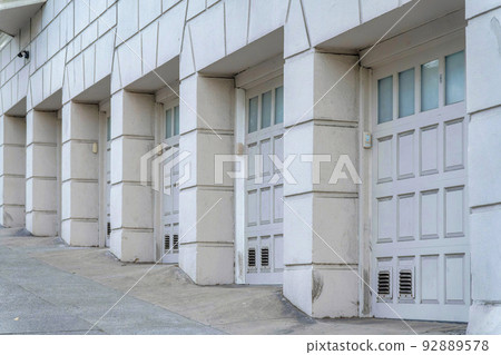 Row of garage doors on a sloped road of an old apartment building at San Francisco, California 92889578