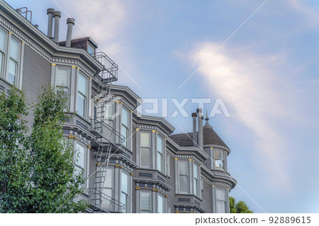 Apartment building exterior with queen anne victorian design in a low angle view 92889615
