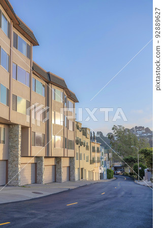 Row of apartment buildings with attached garages near the road in San Francisco, CA Row of apartment buildings with attached garages near the road in San Francisco, CA 92889627