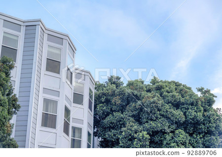 Townhouse exterior with bay windows and trees outdoors in San Francisco, California Townhouse exterior with bay windows and trees outdoors in San Francisco, California 92889706
