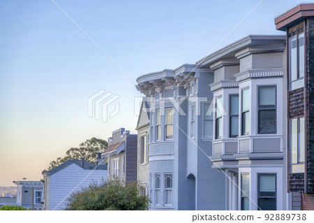 Row of large house buildings against the sunset skyline in San Francisco, California 92889738
