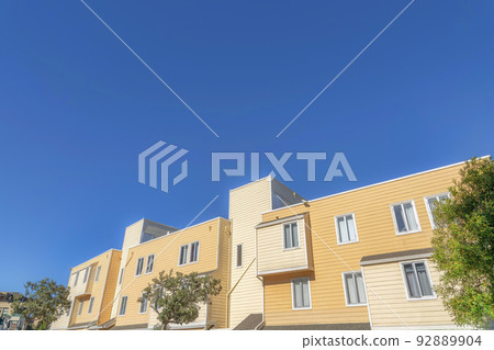 Exterior of an apartment building with beige and yellow wood lap siding in San Francisco, California Exterior of an apartment building with beige and yellow wood lap siding in San Francisco, California 92889904
