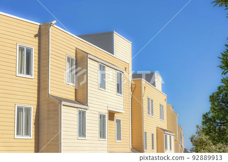 Apartment building exterior with yellow wood lap siding in San Francisco, California Apartment building exterior with yellow wood lap siding in San Francisco, California 92889913