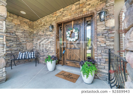 Entrance of a house with stone walls lockbox on the wooden front door with two sidelights in Utah Entrance of a house with stone walls lockbox on the wooden front door with two sidelights in Utah 92889943