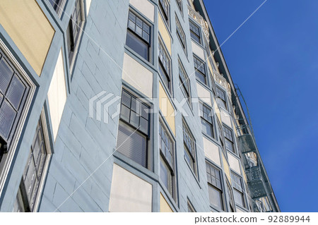 Low angle view of a multi-storey apartment in San Francisco, CA with blue, beige, and white exterior Low angle view of a multi-storey apartment in San Francisco, CA with blue, beige, and white exterior 92889944
