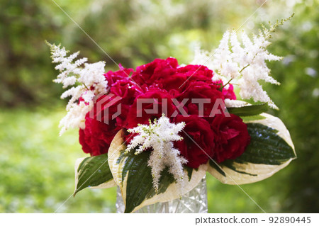 red, pink roses bouquet in crystal vase with rain drops closeup photo on summer green garden background red, pink roses bouquet in crystal vase with rain drops closeup photo on summer green garden background 92890445