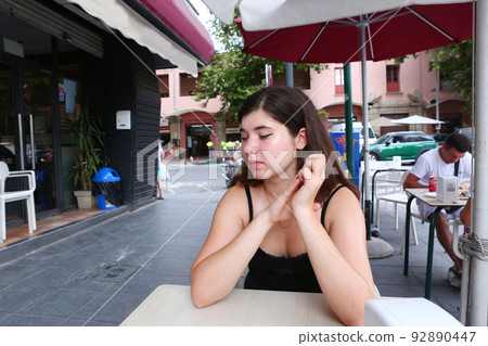 teenager girl with long dark hairs in open air summer cafe close up photo teenager girl with long dark hairs in open air summer cafe close up photo 92890447