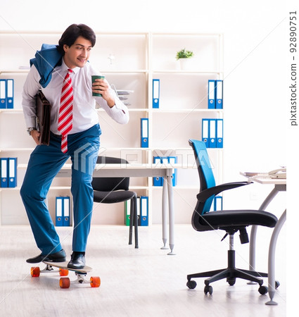 Young handsome businessman with longboard in the office Young handsome businessman with longboard in the office 92890751