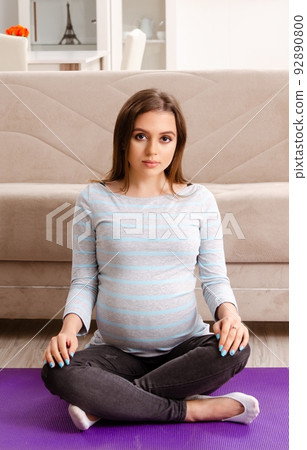 Young pregnant woman doing sport exercises at home 92890800