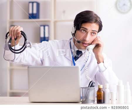 Young male doctor in telemedicine concept Young male doctor in telemedicine concept 92890801