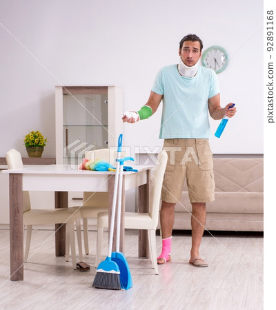 Young injured man cleaning the house Young injured man cleaning the house 92891168