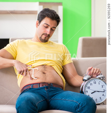 Man measuring body fat with calipers in time management concept 92891269